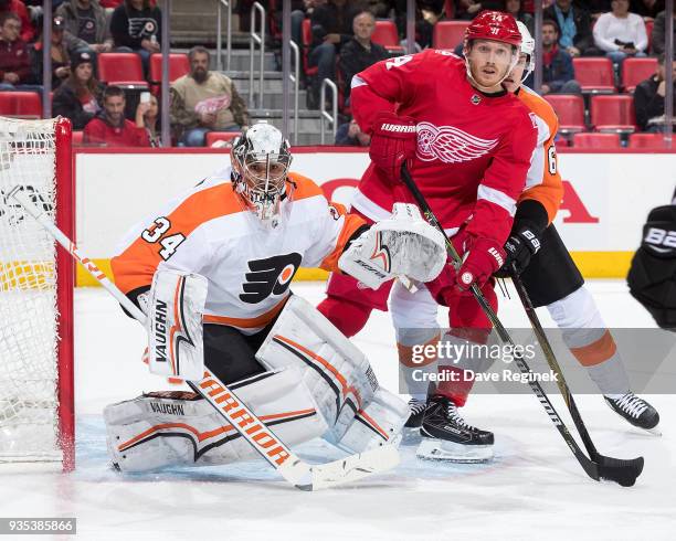 Gustav Nyquist of the Detroit Red Wings looks for a pass in front of the net while being defended by Travis Sanheim of the Philadelphia Flyers in...