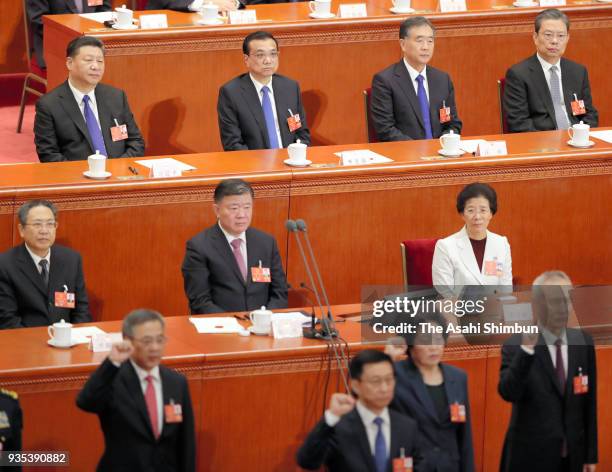 Chinese President Xi Jinping watches delegation swearing an oath during the seventh plenary session of the 13th National People's Congress at the...