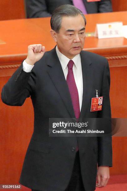 State Councilor Wang Yi swears an oath during the seventh plenary session of the 13th National People's Congress at the Great Hall of the People on...