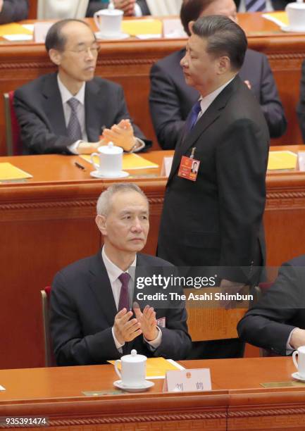 Chinese President walks past newly elected Vice Premier Liu He during the seventh plenary session of the 13th National People's Congress at the Great...