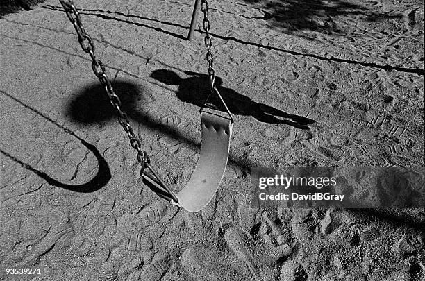 infanzia ricordi: altalena vuota con ombra del bambino - abuso di minore foto e immagini stock