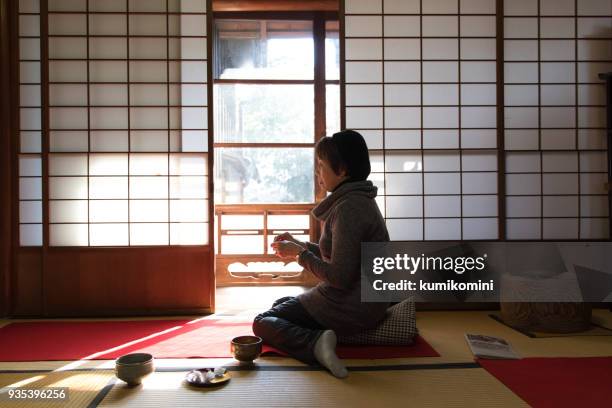 mujer japonesa beber matcha en habitación tradicional - shoji fotografías e imágenes de stock