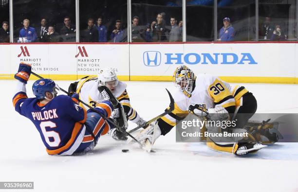 Olli Maatta of the Pittsburgh Penguins takes a penalty for holding Ryan Pulock of the New York Islanders during the second period at the Barclays...