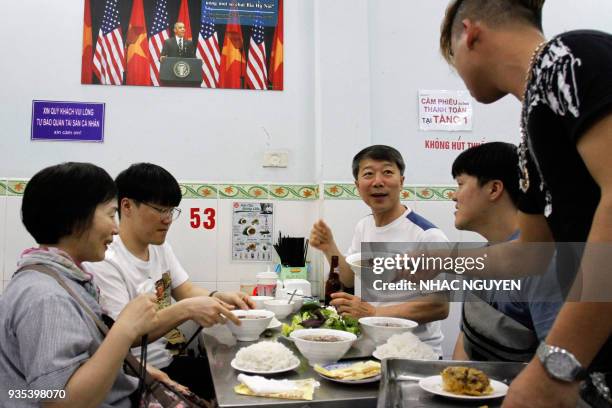 In this photograph taken on March 20 customers enjoy a meal at Bun Cha Huong Lien restaurant, now dubbed "bun cha Obama" with a photograph of former...