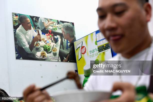 In this photograph taken on March 20 a customer enjoys a meal at Bun Cha Huong Lien restaurant, now dubbed "bun cha Obama" with a photograph of...