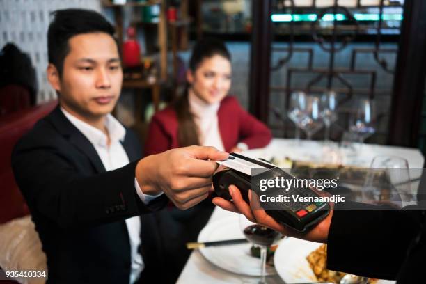 friends in chinese restaurant - paying for dinner imagens e fotografias de stock