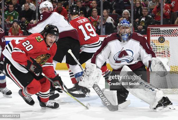 Brandon Saad of the Chicago Blackhawks skates next to goalie Semyon Varlamov of the Colorado Avalanche as he watches the puck in the first period at...