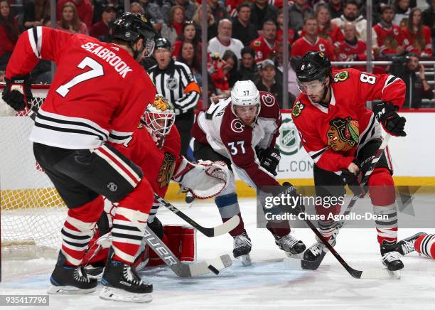 Compher of the Colorado Avalanche and Nick Schmaltz of the Chicago Blackhawks work to get at the puck next to goalie Anton Forsberg in the first...