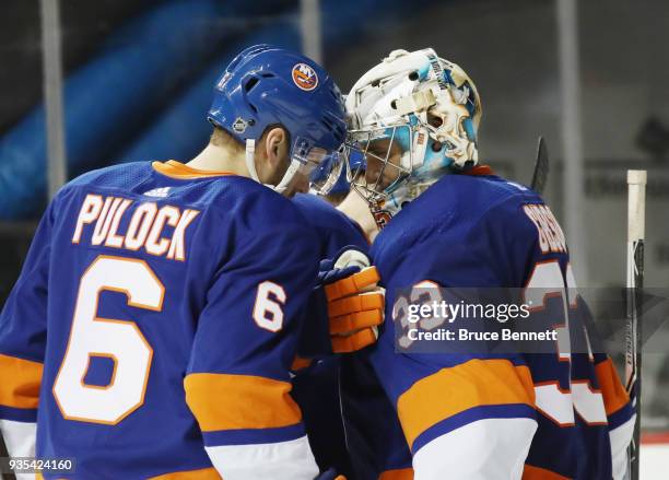 Ryan Pulock and Christopher Gibson of the New York Islanders celebrate a 4-1 victory over the Pittsburgh Penguins at the Barclays Center on March 20,...