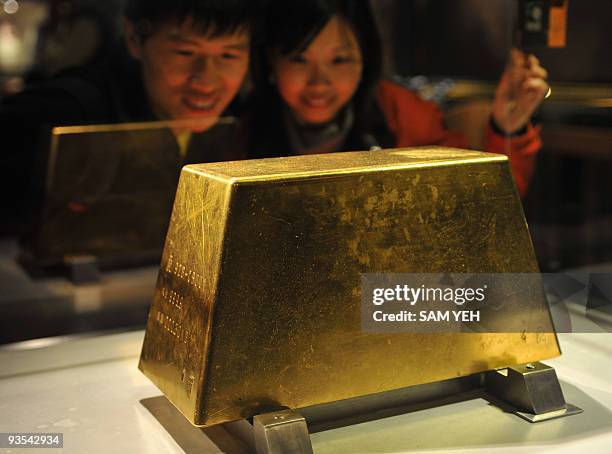 Couple admire the world's largest solid gold brick weighing 220kg, at the Jinguashi Gold Museum in Ruifang, Taipei county, on December 2, 2009. Hong...