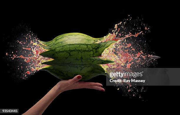 bullet passing through watermelon - slow motion stock pictures, royalty-free photos & images