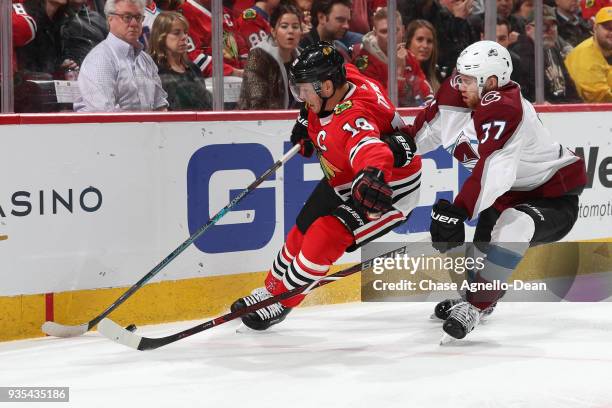 Jonathan Toews of the Chicago Blackhawks and J.T. Compher of the Colorado Avalanche chase the puck in the second period at the United Center on March...