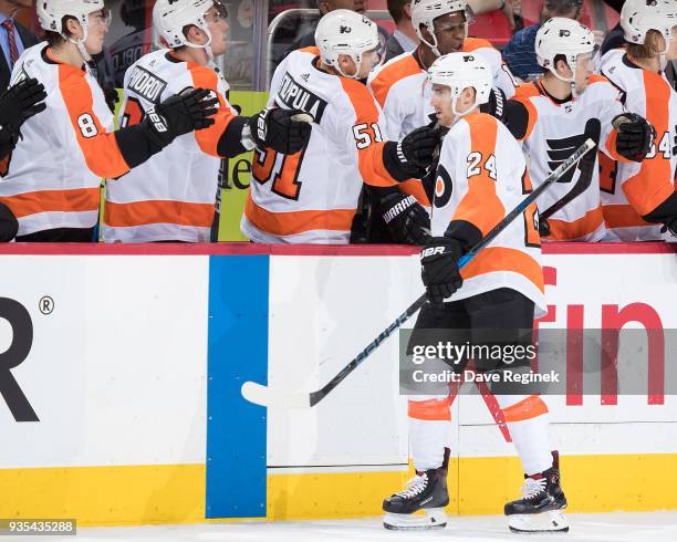 Matt Read of the Philadelphia Flyers pounds gloves with teammates on the bench following his third period goal during an NHL game against the Detroit...