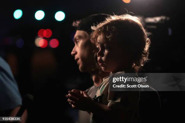 Sam Truitt holds his son Royce while speaking to the press about what he witnessed after a person was injured by a package containing an incendiary...