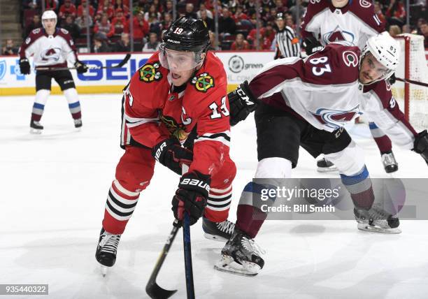 Jonathan Toews of the Chicago Blackhawks and Matt Nieto of the Colorado Avalanche watch for the puck in the third period at the United Center on...