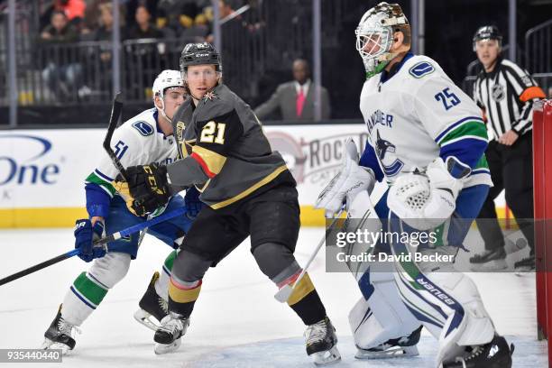 Troy Stecher and goalie Jacob Markstrom of the Vancouver Canucks defend their goal against Cody Eakin of the Vegas Golden Knights during the game at...