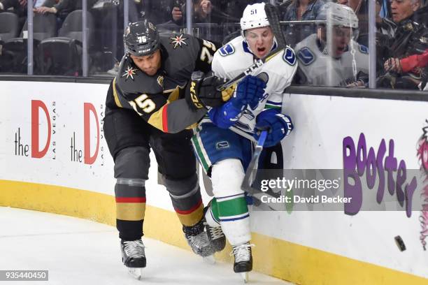 Ryan Reaves of the Vegas Golden Knights and Troy Stecher of the Vancouver Canucks battle for the puck during the game at T-Mobile Arena on March 20,...