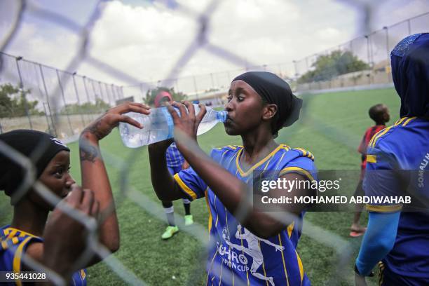 Somali football players of Golden Girls Football Centre, Somalia's first female soccer club, drink water during their training session at Toyo...