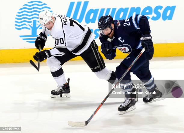 Tanner Pearson of the Los Angeles Kings and Blake Wheeler of the Winnipeg Jets follow the play up the ice during third period action at the Bell MTS...