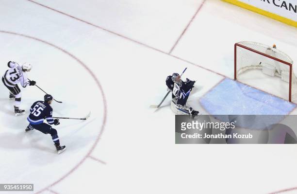 Mark Scheifele and goaltender Eric Comrie of the Winnipeg Jets watch as a shot by Tyler Toffoli of the Los Angeles Kings hits the goal post during...