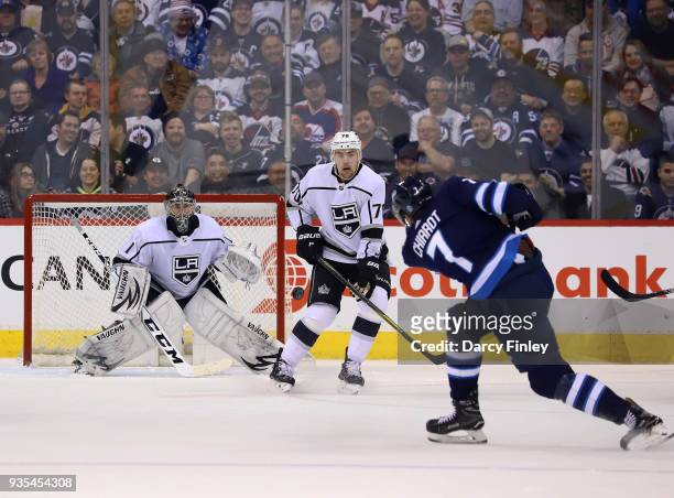 Goaltender Jack Campbell and Tanner Pearson of the Los Angeles Kings watch as Ben Chiarot of the Winnipeg Jets takes a shot off the point during...
