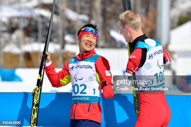 Winner Yoshihiro Nitta of Japan celebrates with Bronze medallist Mark Arendz of Canada after the victory ceremony for the Cross Country Men's 10km...