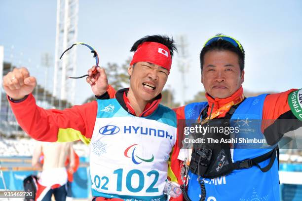 Yoshihiro Nitta of Japan celebrates winning the gold medal in the Cross Country Men's 10km Classic - Standing with team coach Hideki Arai on day...