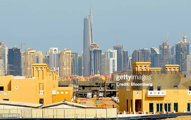 Construction continues on villas, as high rise developments stand in the background, in Dubai, United Arab Emirates, on Wednesday, Dec. 2, 2009....