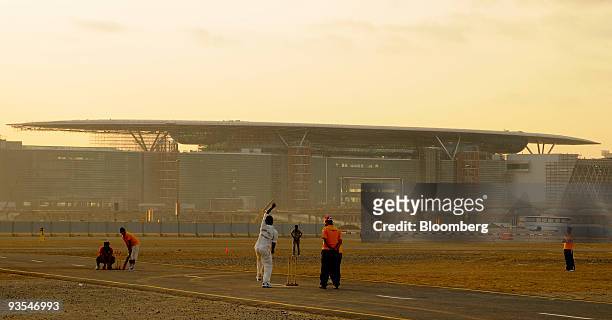 People play cricket in front of the Meydan City racecourse and sports centre in Dubai, United Arab Emirates, on Wednesday, Dec. 2, 2009. Prince...