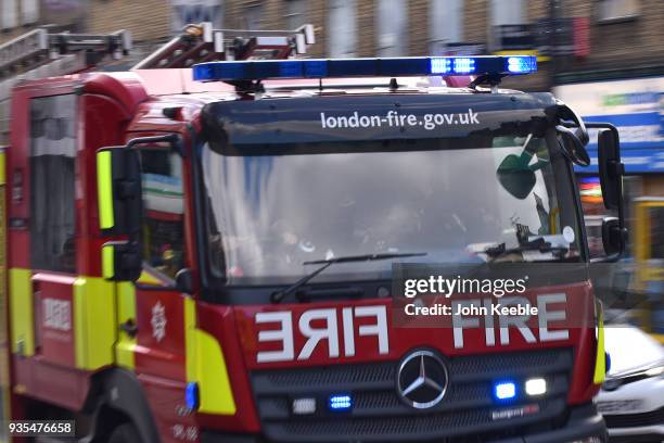 An emergency Fire engine responds to an emergency with blue lights flashing along Camden High Street on March 19, 2018 in London, England.