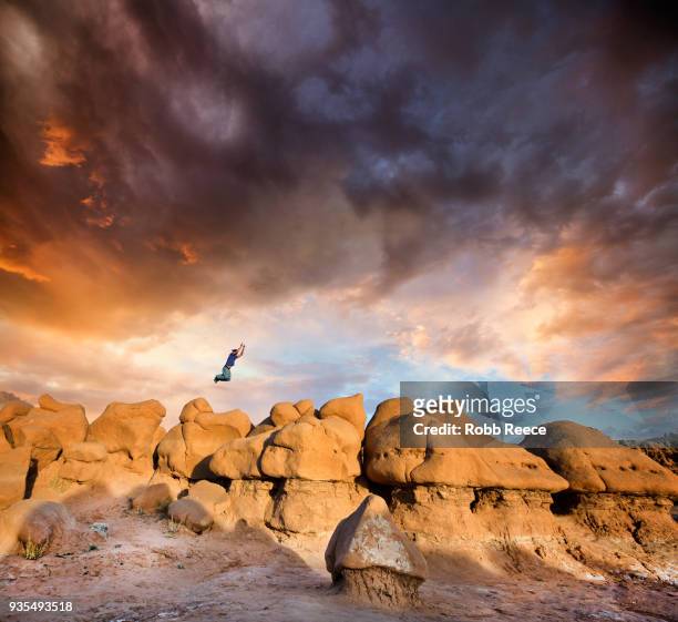 a man doing parkour on rocks in the desert - robb reece stock-fotos und bilder