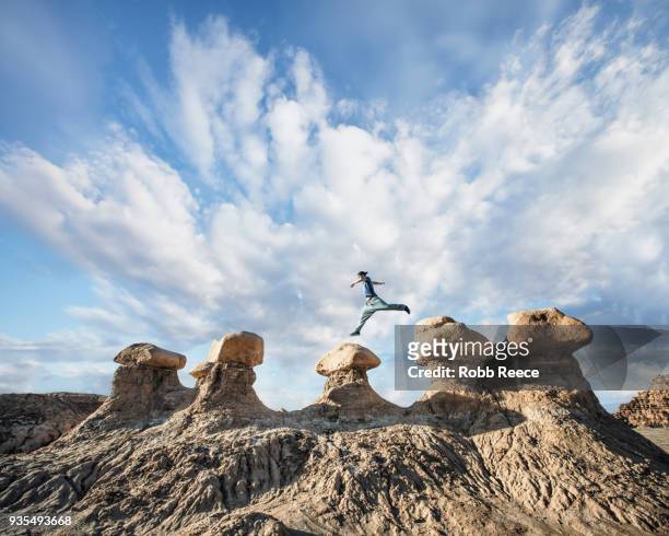a man doing parkour on rocks in the desert - robb reece stockfoto's en -beelden