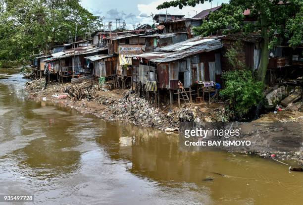People who live in shanty houses by the river banks use the river as their garbage dump, as seen in Jakarta, on March 21, 2018. / AFP PHOTO / BAY...