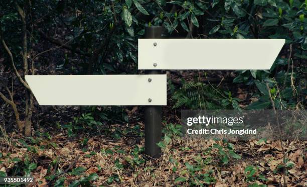 arrow signs at junction. - split road sign stock pictures, royalty-free photos & images