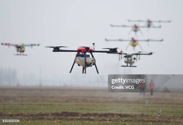 Operators use drones to spray pesticides and nutrient solution on winter wheat on March 21, 2018 in Cangzhou, Hebei Province of China.