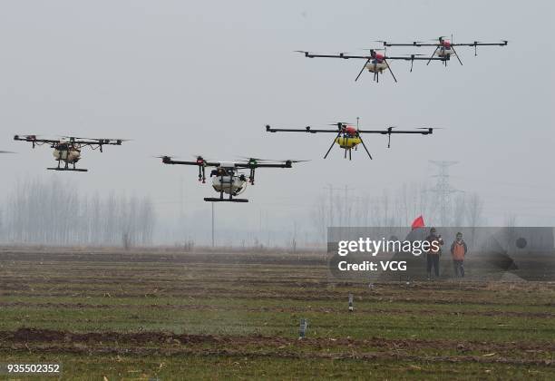 Operators use drones to spray pesticides and nutrient solution on winter wheat on March 21, 2018 in Cangzhou, Hebei Province of China.