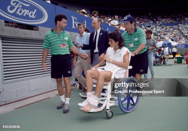 Gabriela Sabatini of Argentina is taken off the court in a wheelchair after suffering an ankle injury during the Australian Open Tennis Championships...