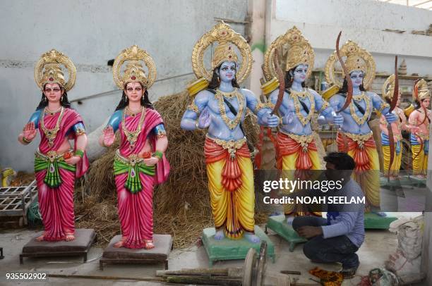 An Indian artist applies final touches to a statue of Hindu god Lord Rama at a workshop in Hyderabad on March 21 ahead of the festival of Rama...