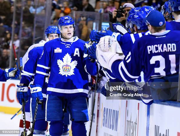 Colin Greening of the Toronto Marlies celebrates his goal with teammates on the bench against the Laval Rocket during AHL game action on March 12,...