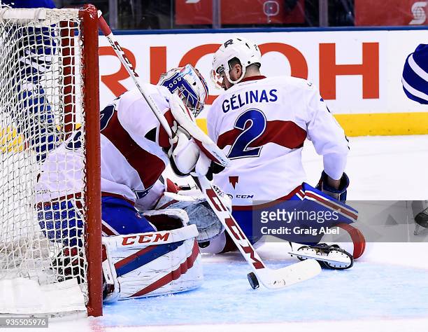 Eric Gelinas helps goalie Zachary Fucale of the Laval Rocket make a save against the of the Toronto Marlies during AHL game action on March 12, 2018...