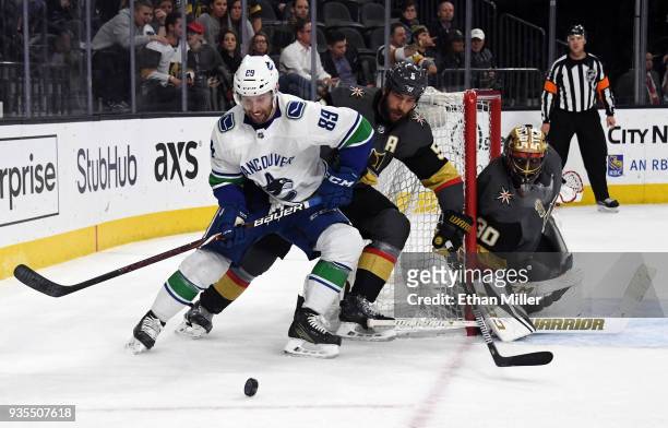 Sam Gagner of the Vancouver Canucks skates with the puck against Deryk Engelland of the Vegas Golden Knights as Malcolm Subban of the Golden Knights...