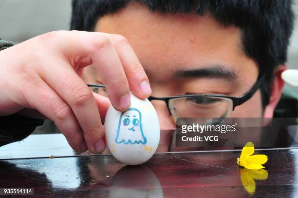 Tourist balances his egg on end to welcome the Spring Equinox day on March 20, 2018 in Jining, Shandong Province of China. The old legend tells us...
