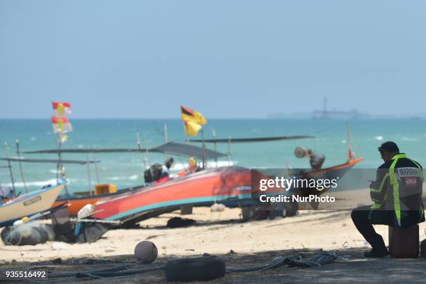 Race marshal takes a break on a beach during a stage three, from Kota Bharu to Juala Terengganu, of the 2018 Le Tour de Langkawi. On Tuesday, March...