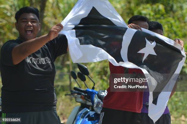 Young men hold the flag Terengganu state during the third stage, a 166km from Kota Bharu to Juala Terengganu, of the 2018 Le Tour de Langkawi. On...