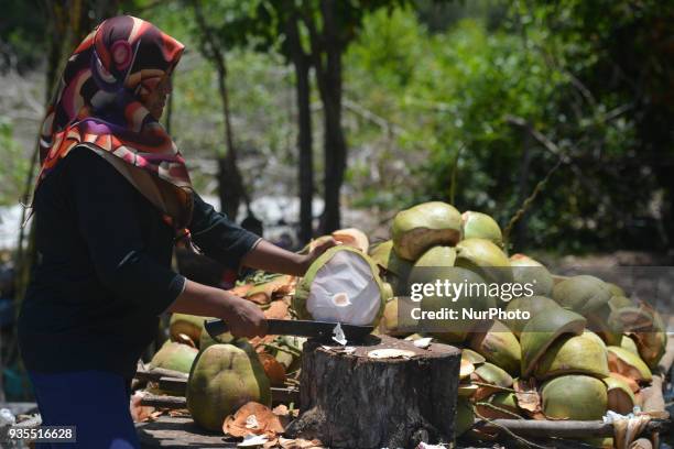 Young lady cuts a coconut on the side of the road as peloton psses by, during the third stage, a 166km from Kota Bharu to Juala Terengganu, of the...