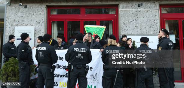 An activist holds a flag of the women's defense unit while the police circled the activists, in Munich, Germany, on March 20, 2018. About 20...