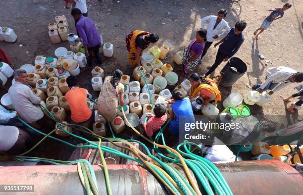 Indian slum dwellers collect potable water from a municipal water tanker in Durga Nagar area of Bhopal on March 21, 2018. Slum dwellers depend on...