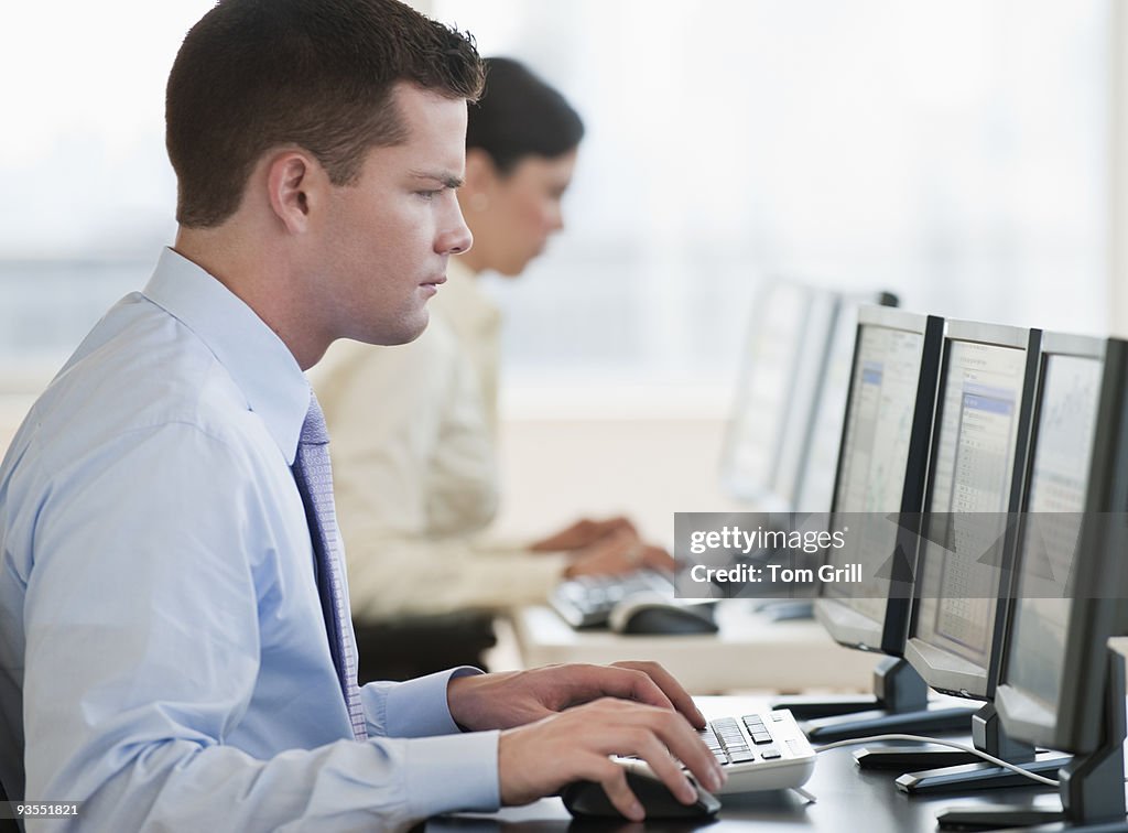 Trader working at computer monitors