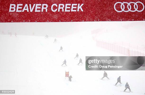 Course workers slip the course trying to remove snow from the course during inspection as Men's FIS Alpine World Cup Training on the Birds of Prey...