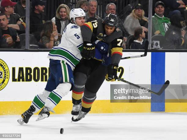 Ryan Reaves of the Vegas Golden Knights tries to get by Derrick Pouliot of the Vancouver Canucks in the second period of their game at T-Mobile Arena...